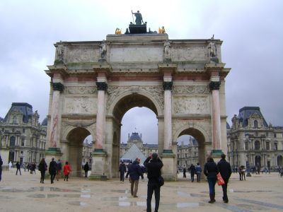 Arco do triunfo com algumas pessoas na frente em Paris