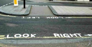 Faixa de pedestres em Londres com instruções pintadas no chão: Look Left e Look Right
