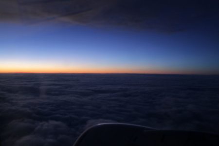 nascer do sol da janela de um avião com nuvens