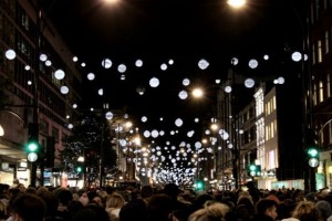 Multidão caminhando sob luzes de Natal na Oxford Street em Londres à noite