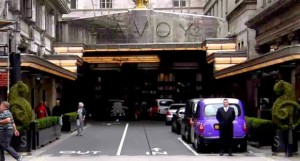 Entrada principal do Hotel Savoy em Londres com táxi londrino roxo.