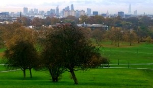 Vista de Londres a partir de Primrose Hill com árvores e gramado verde em primeiro plano