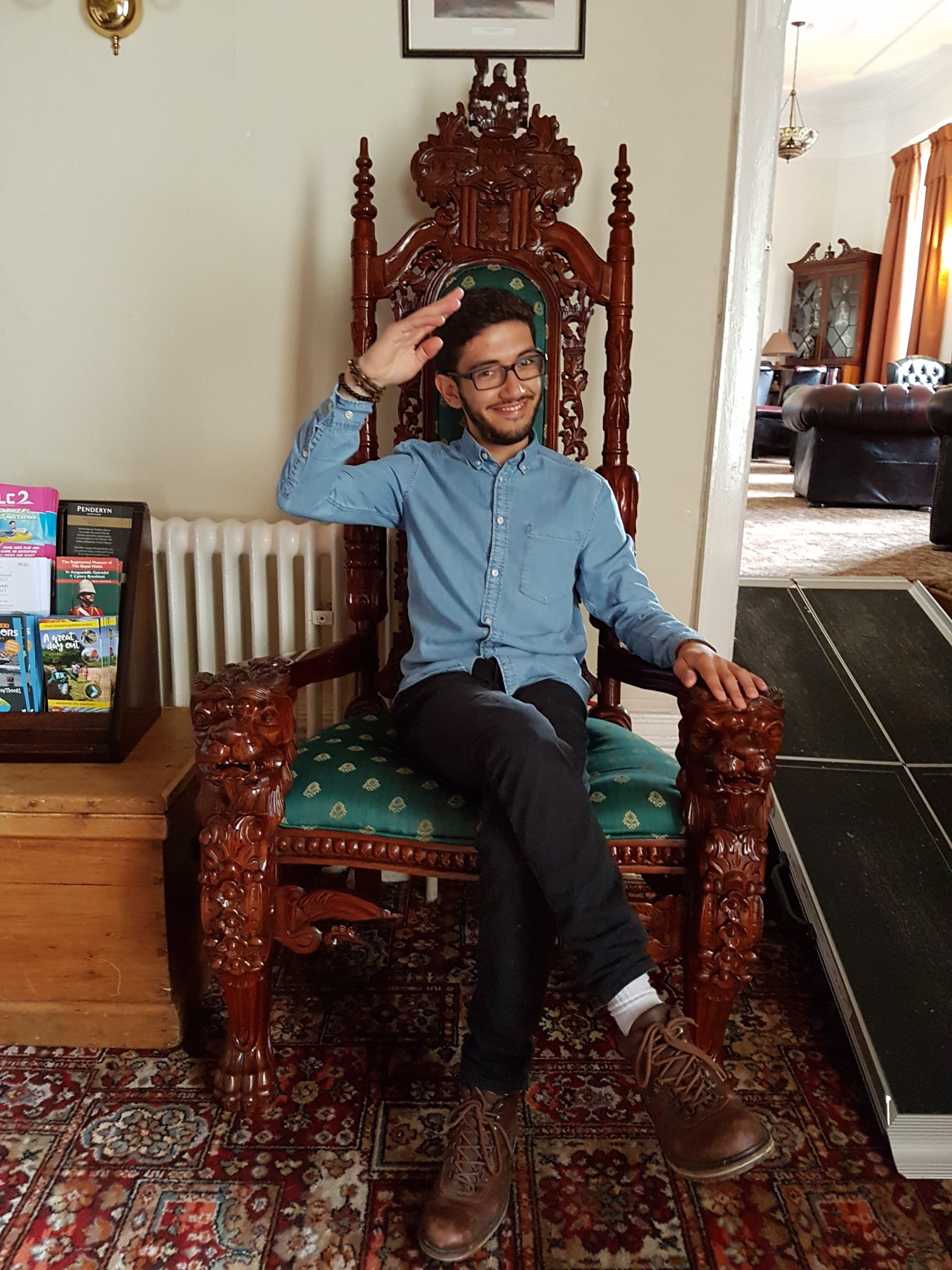 Guri in London sentado numa cadeira a la Game of Thrones fazendo pose.