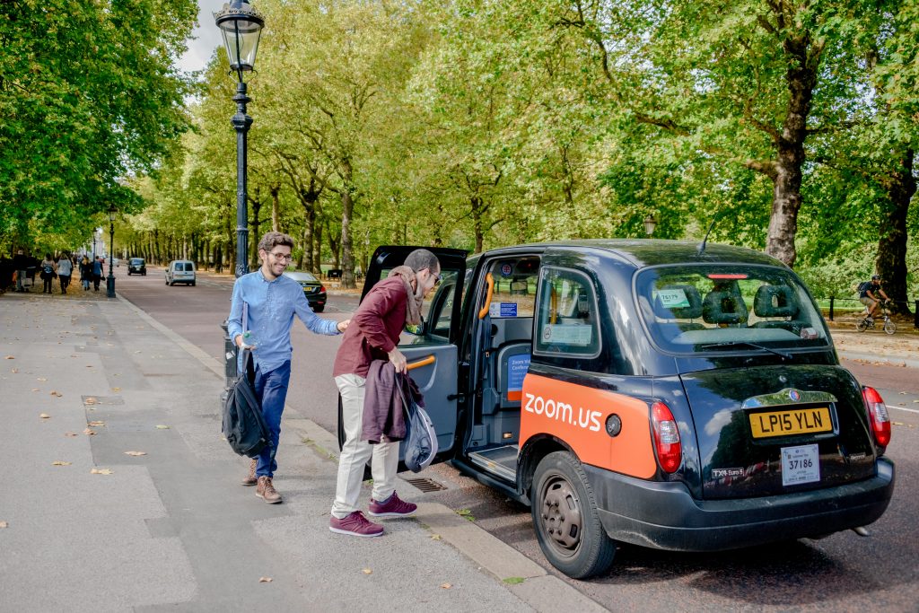 Homens entrando em um taxi preto em Londres. Black cab. The mall com árvores.