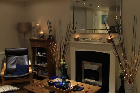 apartamento decorado com velas e lareira e umas prateleiras de madeira. airbnb no pais de gales