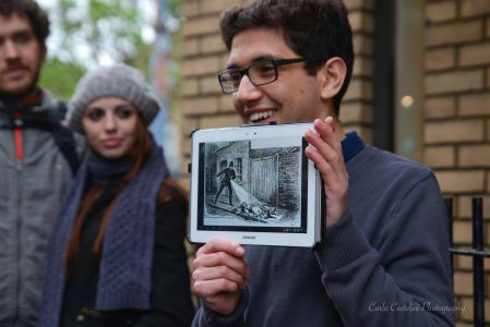 Guia turístico segurando tablet com ilustração de investigação histórica, acompanhado por visitantes atentos.