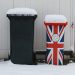 lixeiras com neve em cima, uma lixeira preta e a outra lixeira com a bandeira britanica