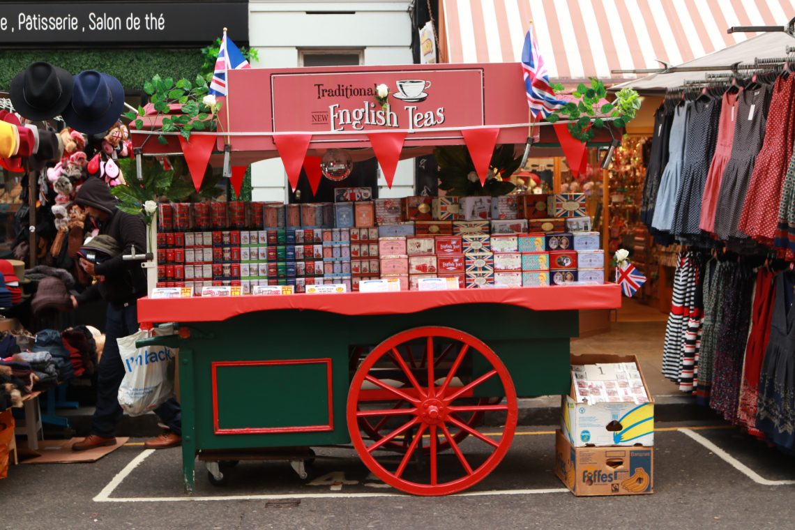 carrinho vermelho de cha em notting hill com a escrita "english tea" e varias caixas de chá