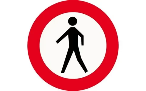Placa de trânsito com símbolo de pedestre dentro de um círculo vermelho e fundo branco, indicando “proibido pedestres” ou “entrada proibida para pedestres”.
