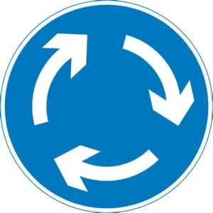 Placa de trânsito circular azul com três setas brancas formando um círculo, indicando “rotatória à frente” ou “trânsito em sentido circular obrigatório”.