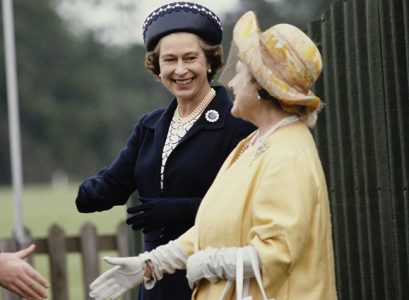 rainha mãe usando uma roupa amarela e chapéu amarelo cumprimentando charles, irmão da princesa diana, 9º earl spencer, ao lado da rainha elizabeth II usando uma roupa azul e por volta de 60 anos