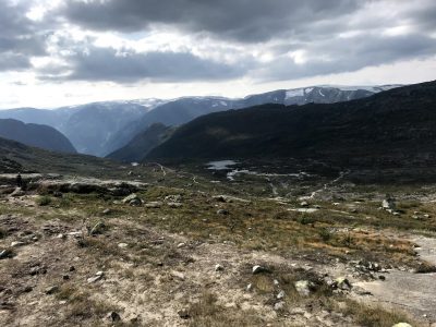 natureza com muitas montanhas e neve na trilha trolltunga com montanhas nevadas ao fundo na noruega