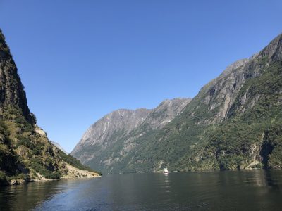 passeio de barco pelos fiordes da noruega com montanhas altas de ambos os lados