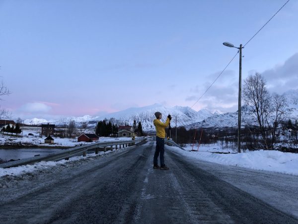 mulher fotogrando uma cidade com neve na noruega