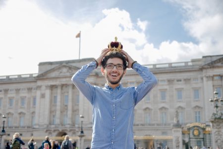 rafa guri in london colocando a coroa na cabeça em frente ao palacio de buckingham no tour da realeza britanica em londres