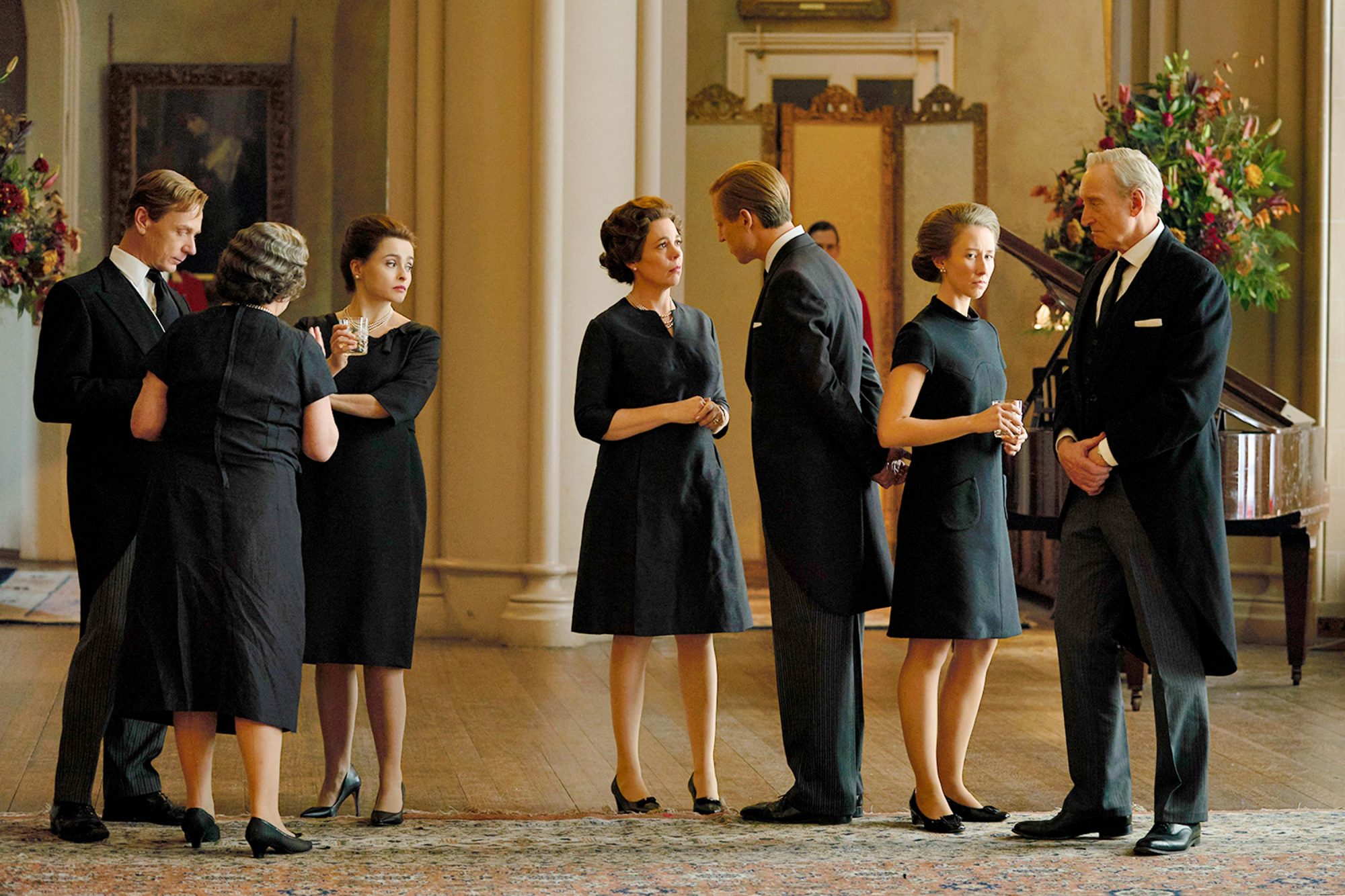The crown família real conversando no palácio de buckingham vestidos de preto