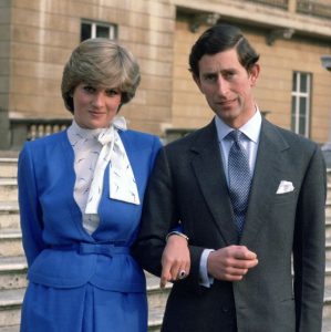 Principe Charles e Diana no dia do anuncio do casamento deles no palacio de Buckigham, diana usando uma roupa azul e charles de terno