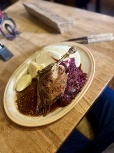 Pato assado servido com repolho roxo e dumplings no estilo de restaurante medieval em Praga