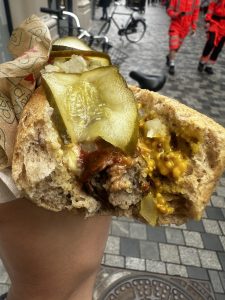 cachorro quente dinamarquês mordido, com salsicha e um intenso molho de mostarda