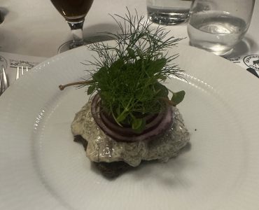 pão de centeio com creme de peixe no topo servido em prato branco, em restaurante de Copenhagen